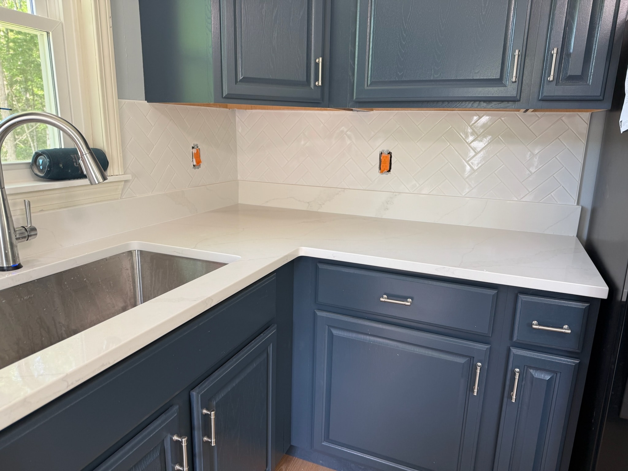 White herringbone tile with navy cabinets